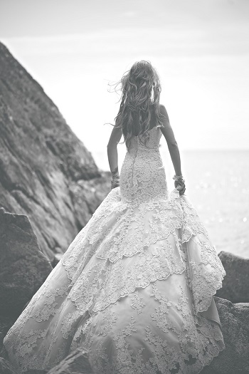 Black and white photo of bride standing on Whytecliff Park rocks