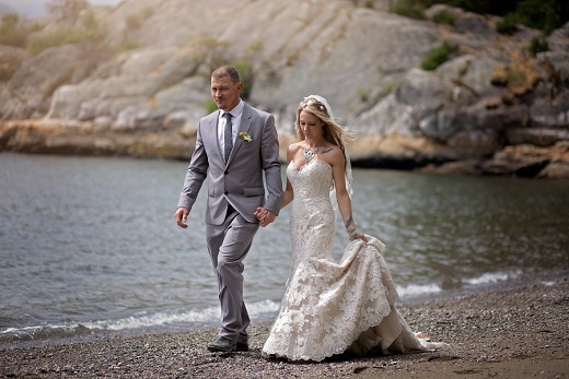 Bride and groom walking along the beach captured by Karizma Photography