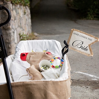 Rustic Burlap themed wagon with a here comes the bride sign