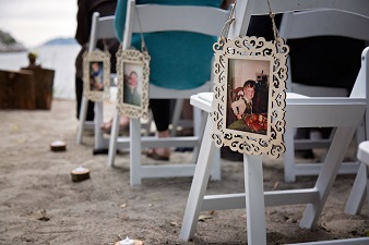 outdoor wedding aisle decor using pictures frames and baby pictures of the bride and groom