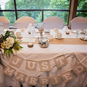 rustic Just married sign hanging from bride party table