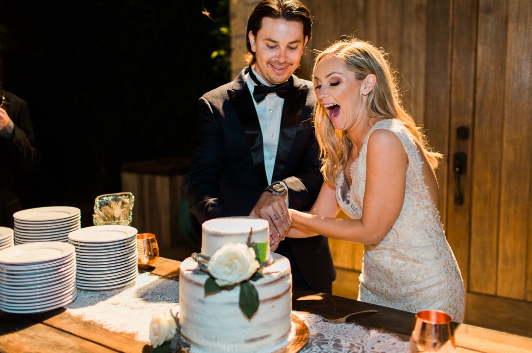 Bride and groom cutting cake captured by Kaitie Brainerd Photography