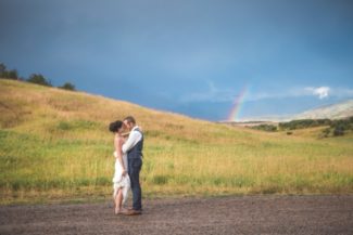 newlyweds with rainbow in background