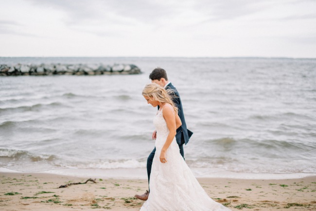 newlyweds walk on beach in Maryland