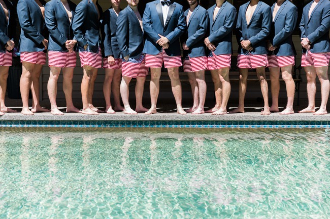groomsmen lined up in red striped trunks with blazers