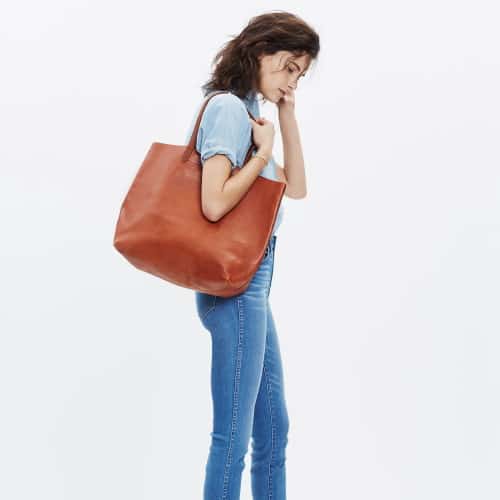woman carrying monogrammed leather tote bag