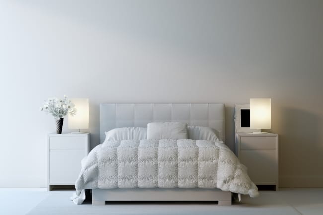 chambre à coucher avec des meubles blancs et une literie blanche