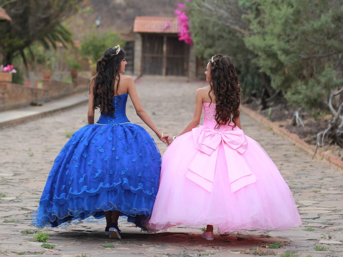 Girls Wearing their Blue and Pink Ball Gowns while Holding Each Other's Hand