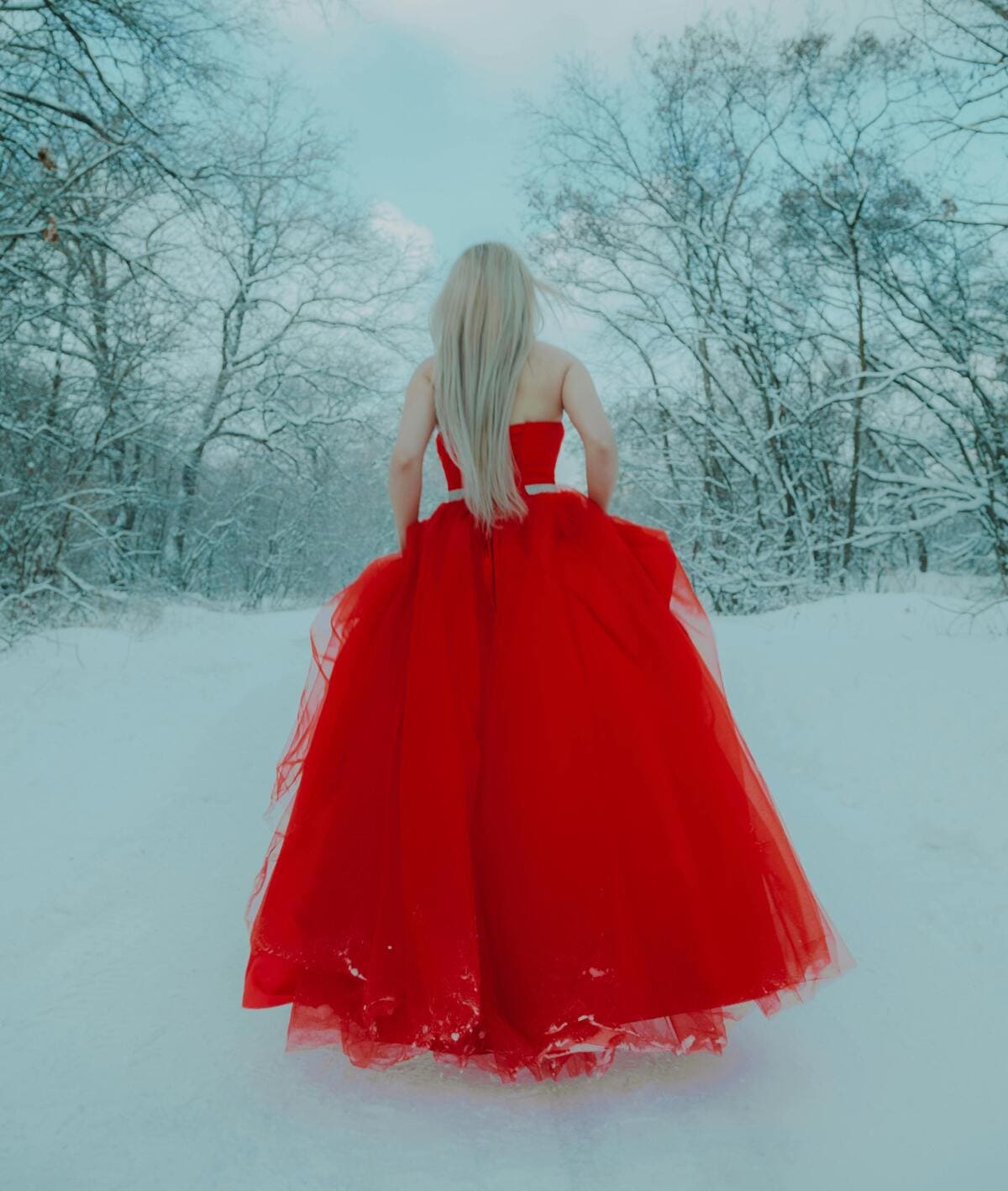 woman in red dress in winter forest
