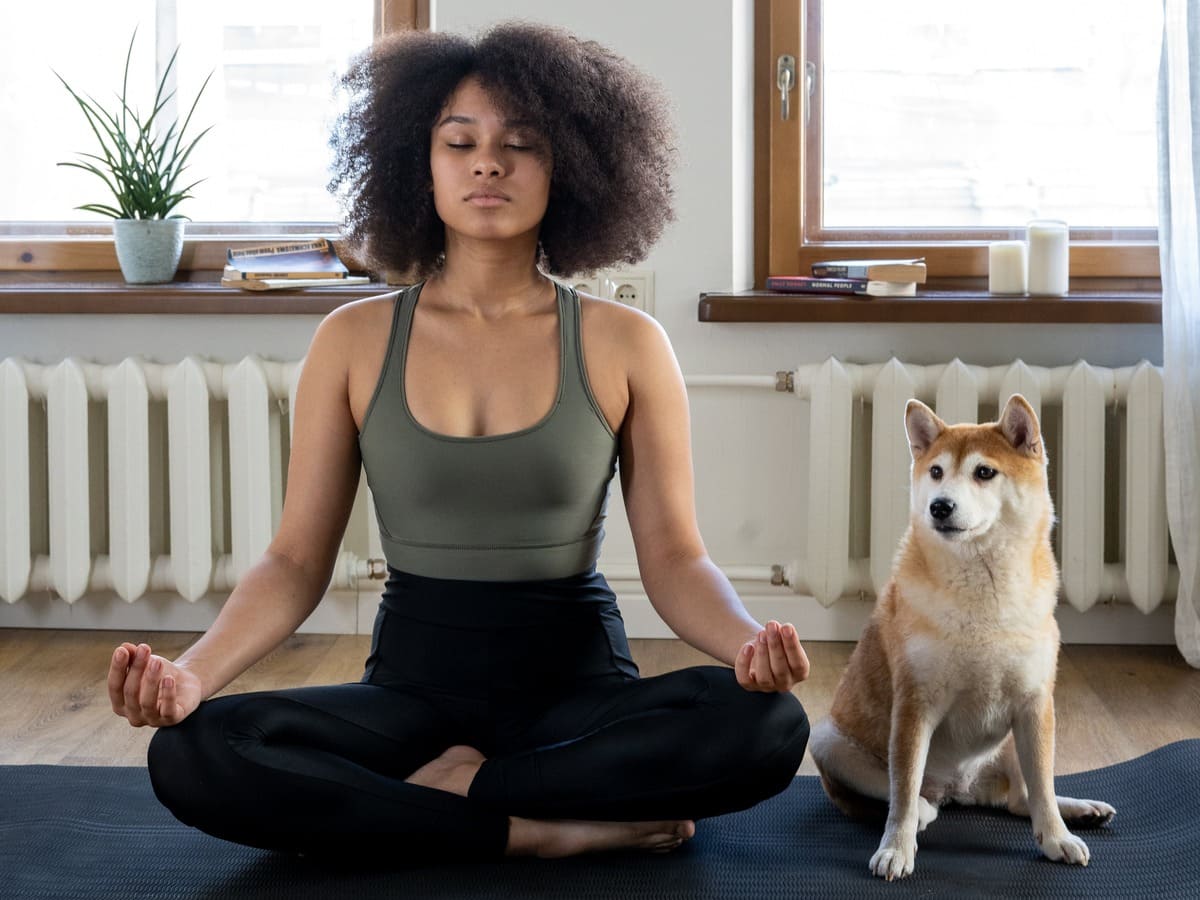Woman Meditating Beside her Dog